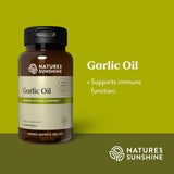 A bottle of Nature's Sunshine Garlic Oil dietary supplement on a solid olive green background, with text on the right stating 'Garlic Oil' and 'Supports immune function.'.