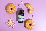 Bottle of Nature's Sunshine SugarReg on a pink background with donuts and candy.