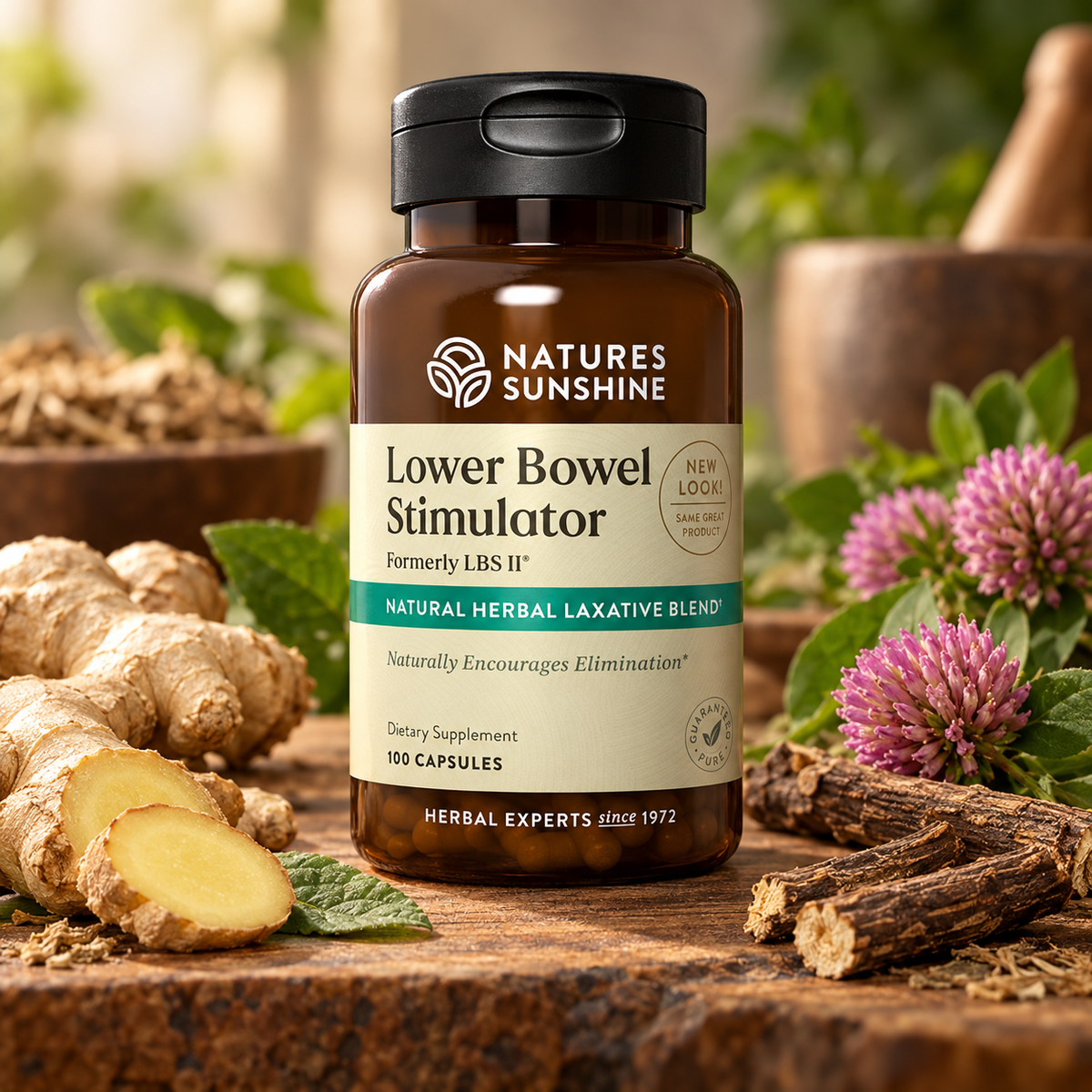 A bottle of Nature's Sunshine Lower Bowel Stimulator dietary supplement, styled on a rustic wooden surface with ginger roots, pink flowers, and herbs in the background.
