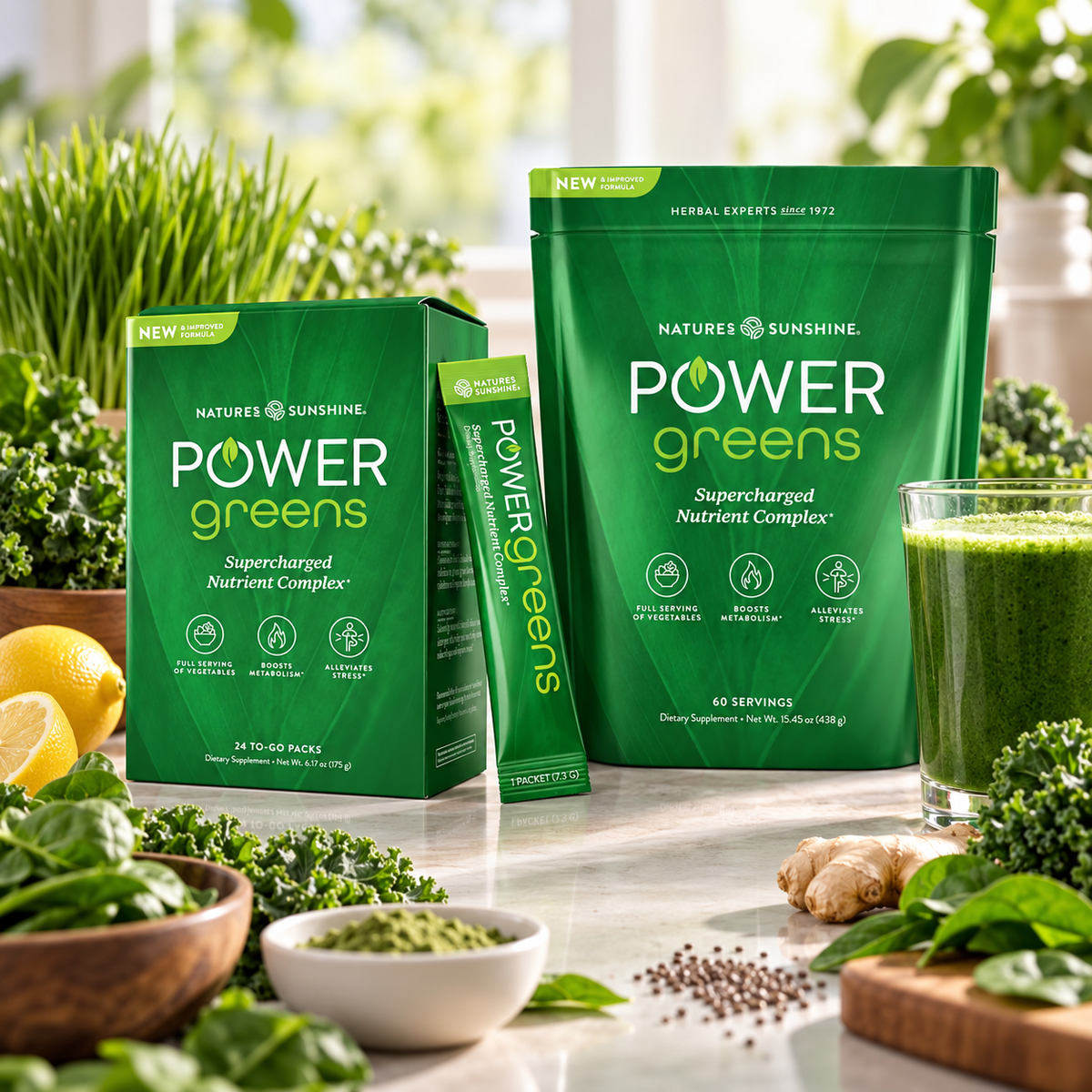 Nature's Sunshine Power Greens herbal supplement set, featuring a large green resealable pouch, a matching box of 24 to-go packs, and a single stick pack, styled on a marble countertop with fresh greens, kale, lemon, ginger, and a glass of green juice.