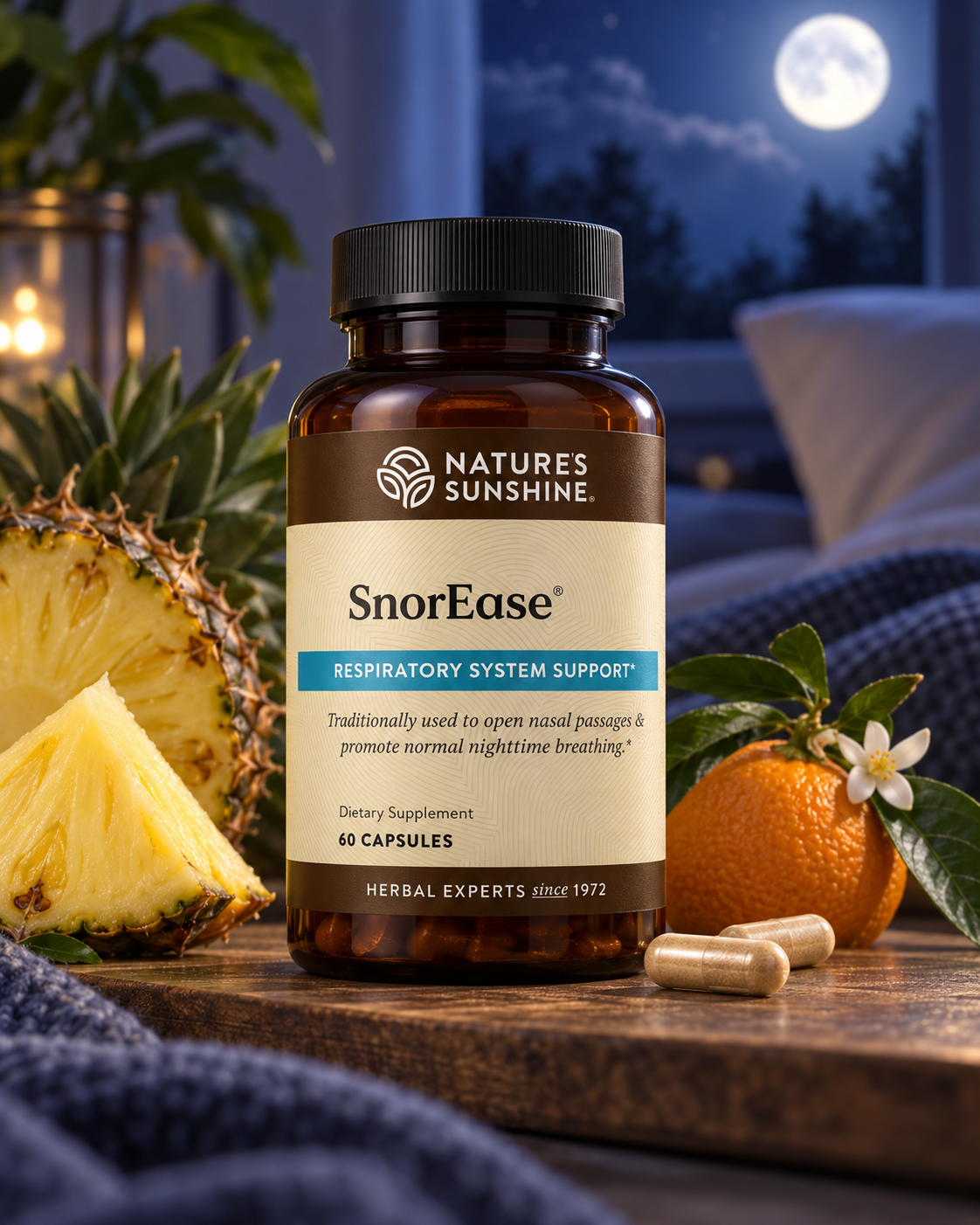 A bottle of Natures Sunshine SnorEase respiratory system support dietary supplement, styled on a wooden table with a pineapple slice, an orange, and two capsules, set against a cozy bedroom background at night with a full moon.