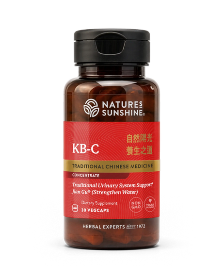 A bottle of Nature's Sunshine KB-C Traditional Chinese Medicine dietary supplement, featuring a dark amber bottle, black cap, and a red label with gold and white text.