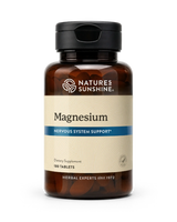 A bottle of Nature's Sunshine Magnesium dietary supplement with 180 tablets, featuring an amber brown bottle, black cap, and a beige label with a blue accent stripe.