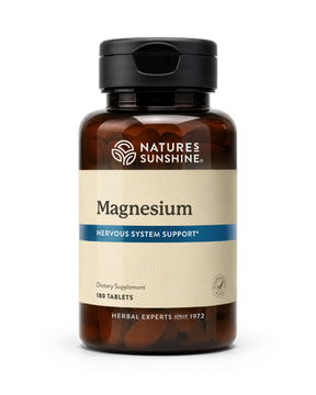 A bottle of Nature's Sunshine Magnesium dietary supplement with 180 tablets, featuring an amber brown bottle, black cap, and a beige label with a blue accent stripe.
