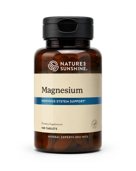 A bottle of Nature's Sunshine Magnesium dietary supplement with 180 tablets, featuring an amber brown bottle, black cap, and a beige label with a blue accent stripe.