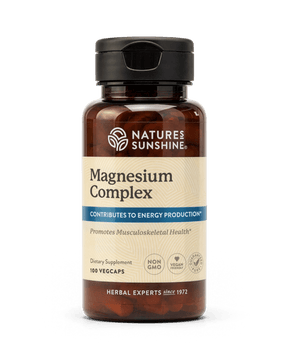 Nature's Sunshine Magnesium Complex dietary supplement bottle with a black cap and amber-brown plastic, containing 100 vegcaps, on a white background.