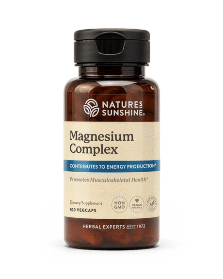 Nature's Sunshine Magnesium Complex dietary supplement bottle with a black cap and amber-brown plastic, containing 100 vegcaps, on a white background.