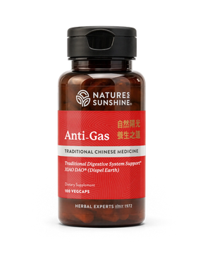 A bottle of Nature's Sunshine Anti-Gas dietary supplement, featuring a dark amber glass bottle, a black cap, and a red label with white and gold text.