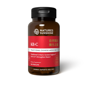 A bottle of Natures Sunshine KB-C Traditional Chinese Medicine dietary supplement, featuring a dark amber brown bottle, a black cap, and a label with red, white, and silver sections.
