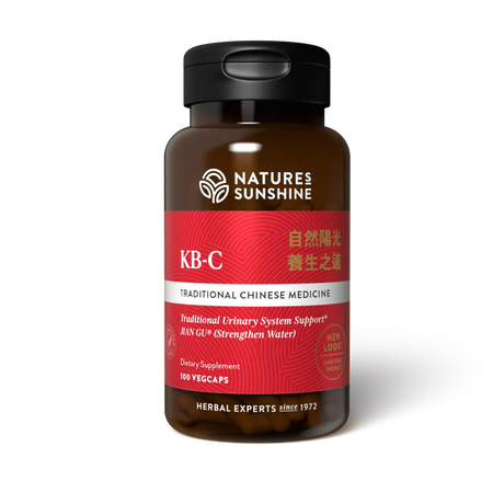 A bottle of Natures Sunshine KB-C Traditional Chinese Medicine dietary supplement, featuring a dark amber brown bottle, a black cap, and a label with red, white, and silver sections.