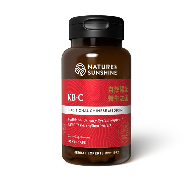 A bottle of Natures Sunshine KB-C Traditional Chinese Medicine dietary supplement, featuring a dark amber brown bottle, a black cap, and a label with red, white, and silver sections.