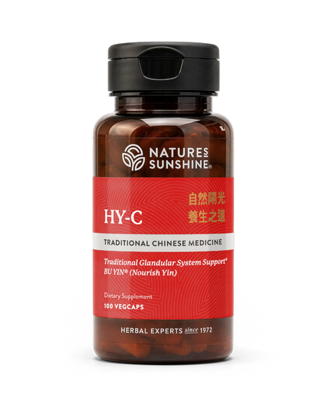 A bottle of Natures Sunshine HY-C Traditional Chinese Medicine dietary supplement, featuring a dark amber bottle, black cap, and a red label with white and gold text.