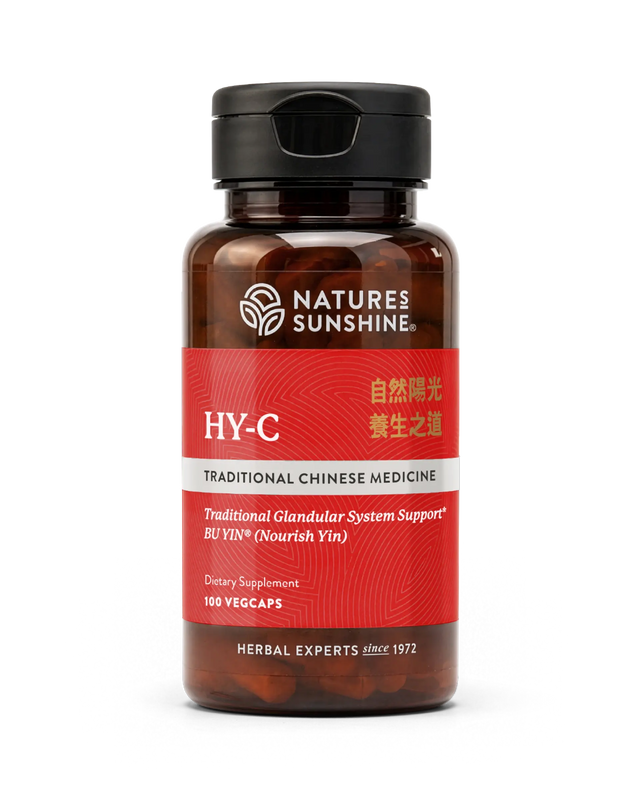 A bottle of Natures Sunshine HY-C Traditional Chinese Medicine dietary supplement, featuring a dark amber bottle, black cap, and a red label with white and gold text.