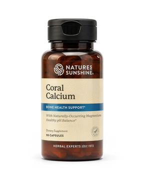 A bottle of Nature's Sunshine Coral Calcium dietary supplement, featuring an amber brown bottle, a black cap, and a beige label with blue accents.