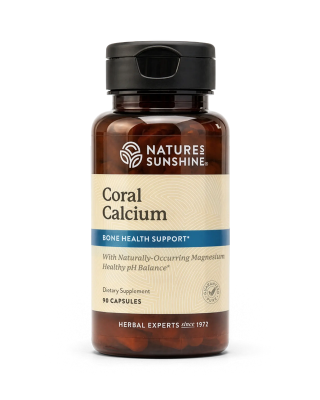 A bottle of Nature's Sunshine Coral Calcium dietary supplement, featuring an amber brown bottle, a black cap, and a beige label with blue accents.