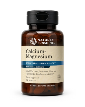 A bottle of Nature's Sunshine Calcium-Magnesium dietary supplement with herbal extracts, featuring an amber brown bottle, black cap, and a beige label with blue accents.