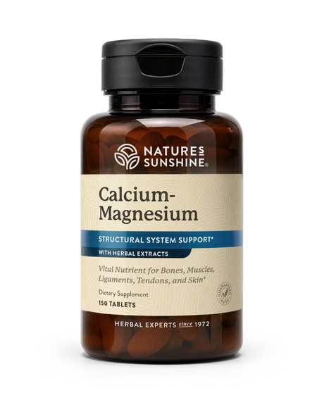 A bottle of Nature's Sunshine Calcium-Magnesium dietary supplement with herbal extracts, featuring an amber brown bottle, black cap, and a beige label with blue accents.