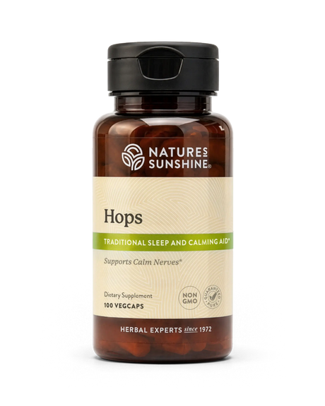 A bottle of Nature's Sunshine Hops dietary supplement with a black cap and amber-brown bottle, featuring a beige label with green accents, on a white background.