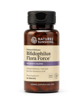 A bottle of Nature's Sunshine Bifidophilus Flora Force probiotic supplement, featuring amber brown plastic, a black cap, and a beige label with purple accents, set against a plain white background.