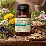 A bottle of Nature's Sunshine Pro-Pancreas Formula dietary supplement, styled on a rustic wooden table surrounded by fresh herbs, flowers, and roots.